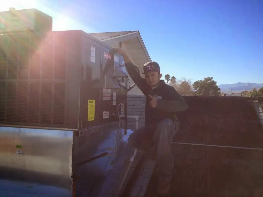 HVAC technician performing AC Tune-Up on a rooftop unit in Cedar Mill